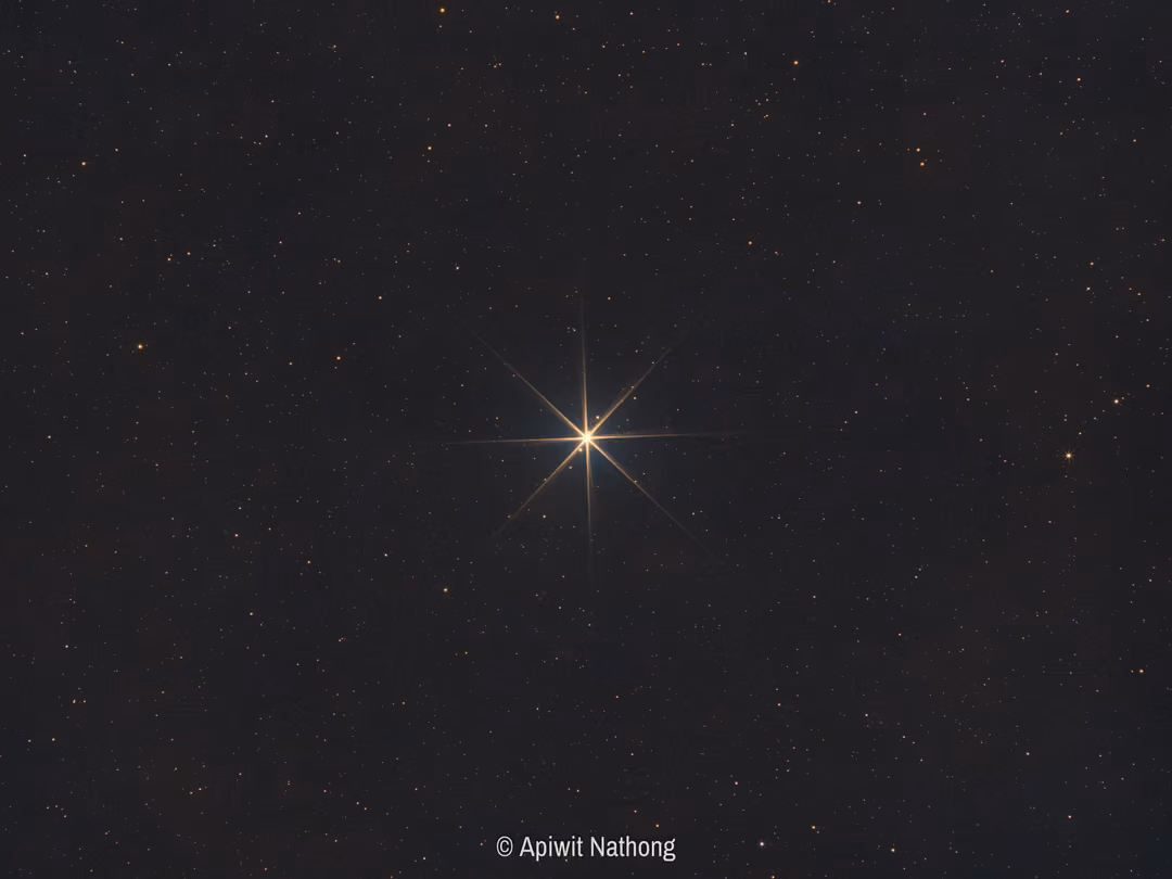 A bright point of light with sharp diffraction spikes in a dark starfield, identified as Jupiter