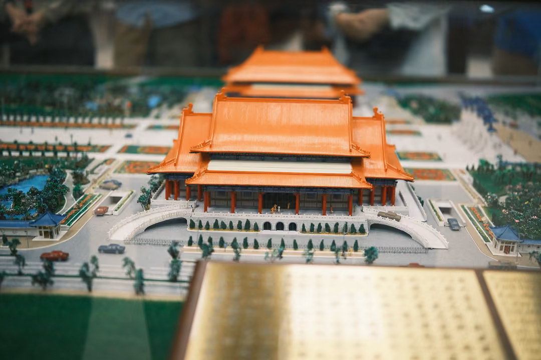 Closer view of the model orange-roofed hall with its tiered roof, steps and surrounding miniature trees