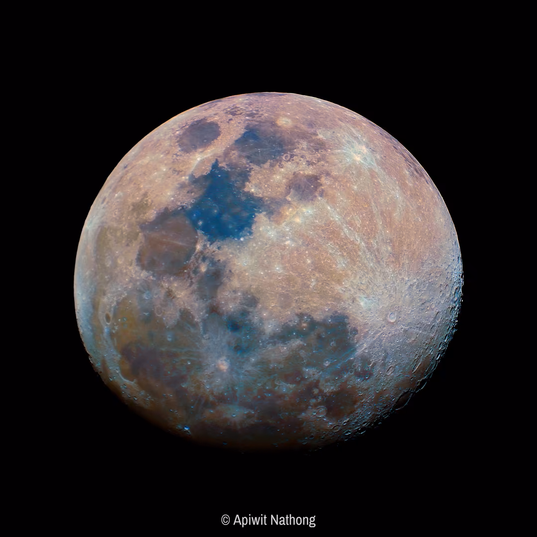 A nearly full moon in vivid false colour, blue maria and golden highlands, pulled from a video