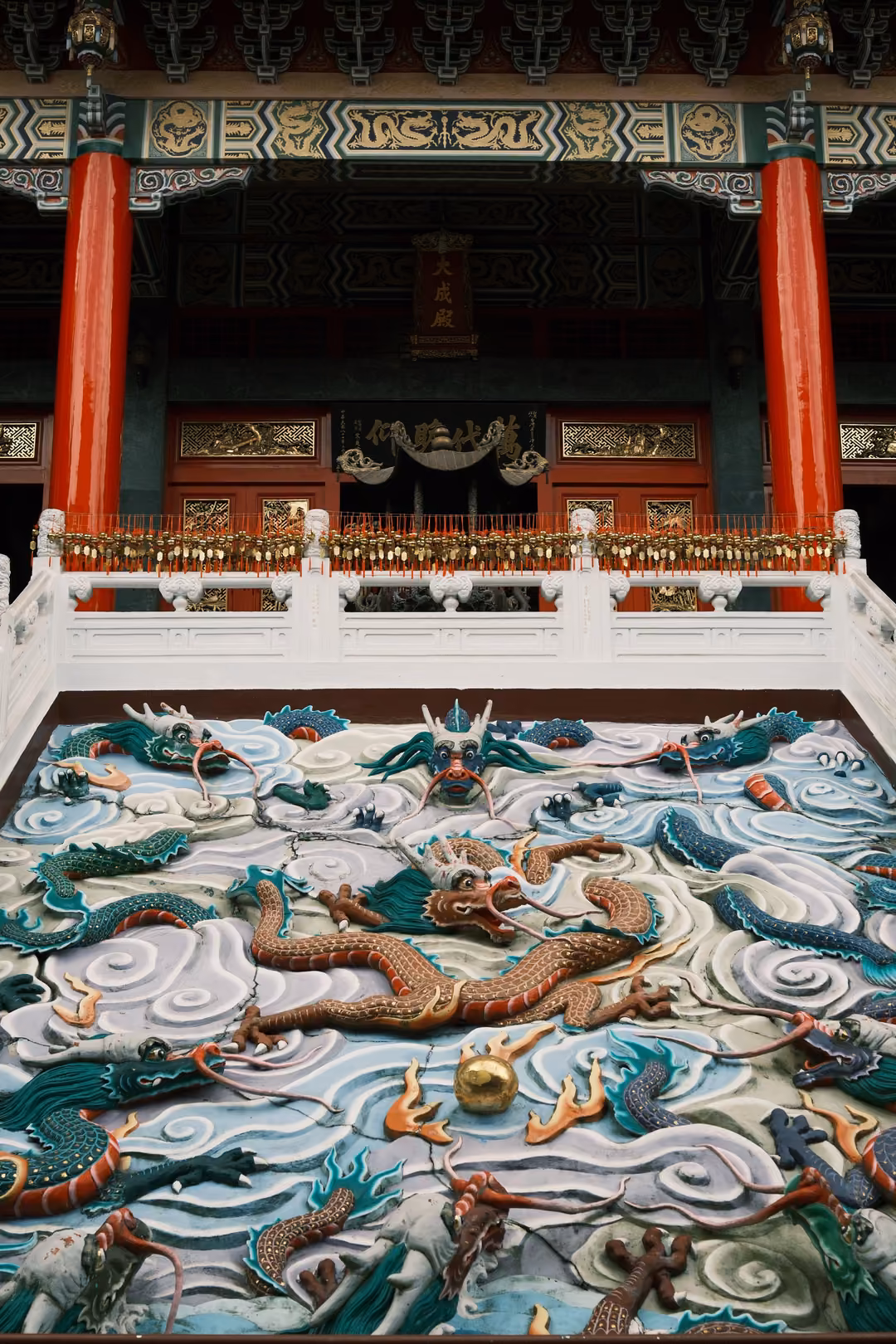 Nearly identical view of the painted dragon slab and the red-pillared hall above, framed slightly wider