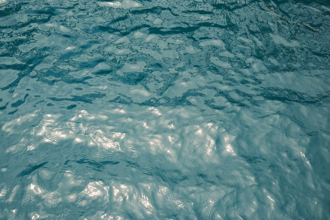 Close view of rippling teal water with bright reflections across its surface