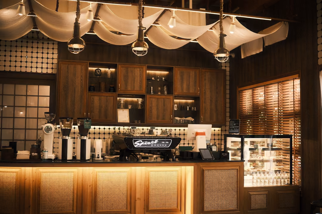 Coffee bar with an espresso machine labelled Spirit, wooden cabinets, pendant lamps and draped fabric ceiling