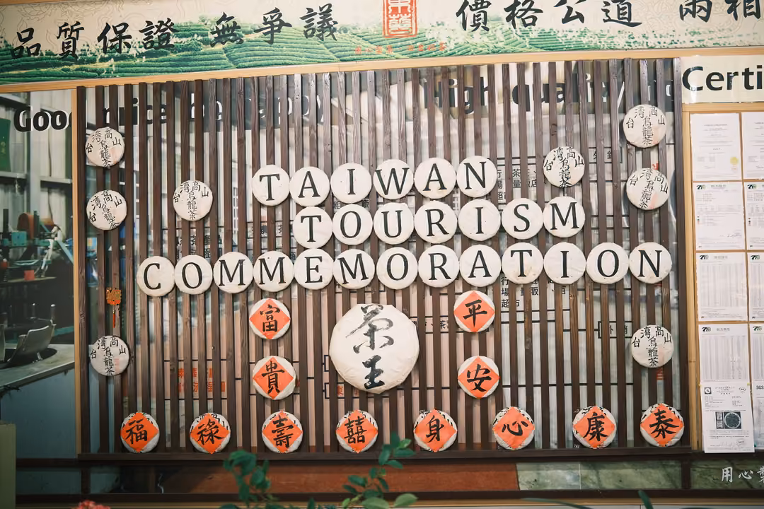 Display wall spelling TAIWAN TOURISM COMMEMORATION in round white plaques with red characters below
