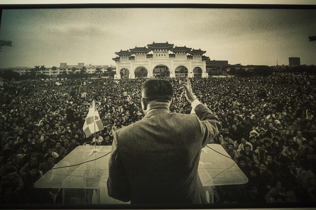 Close view of the black-and-white photograph of a man with a raised arm addressing an enormous crowd