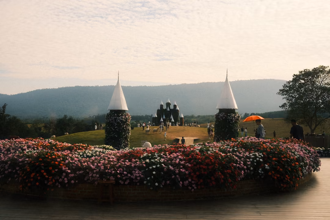 A ring of flowers with two flower-covered cone towers framing the castle and hills in the distance.