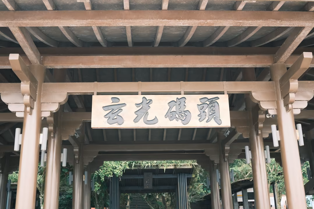 Carved wooden gateway with a plaque reading 玄光碼頭, beams and pillars framing a covered walkway